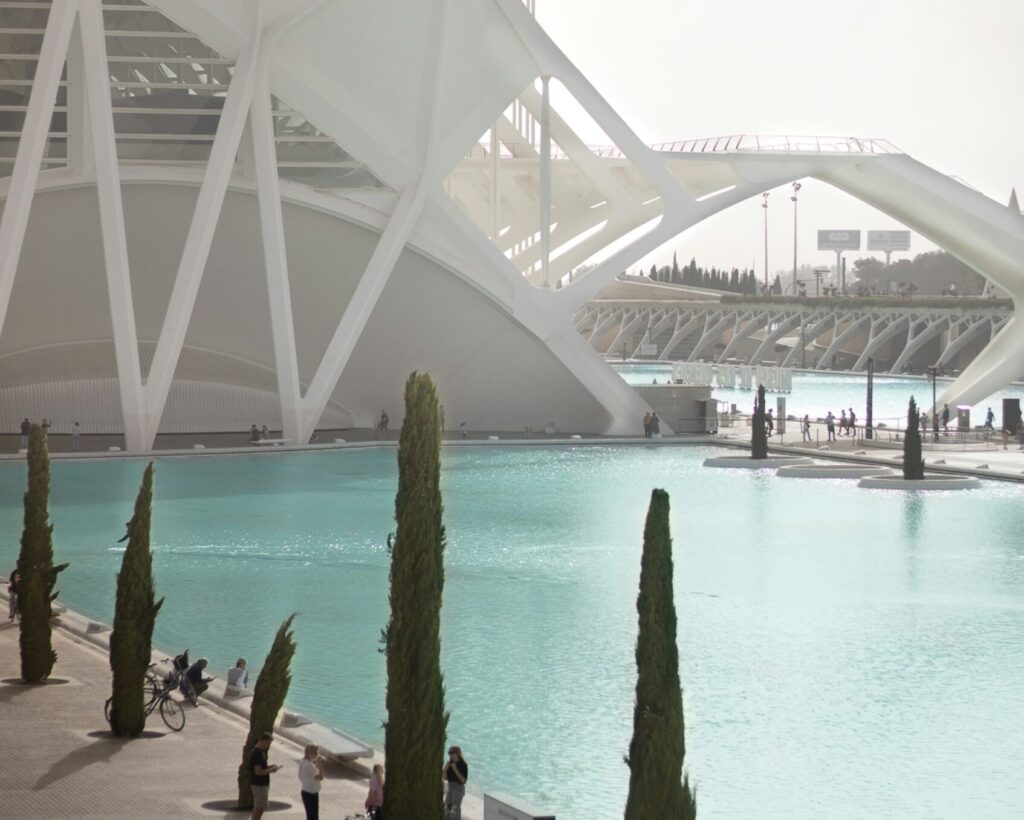 People cycling by the reflecting pool at the Museo de las Ciencias in Valencia, Spain