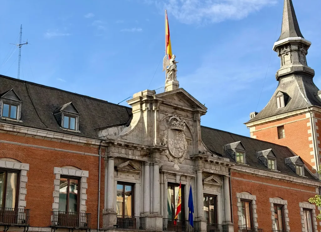 Spanish flag flying above a government building in Madrid against a blue sky