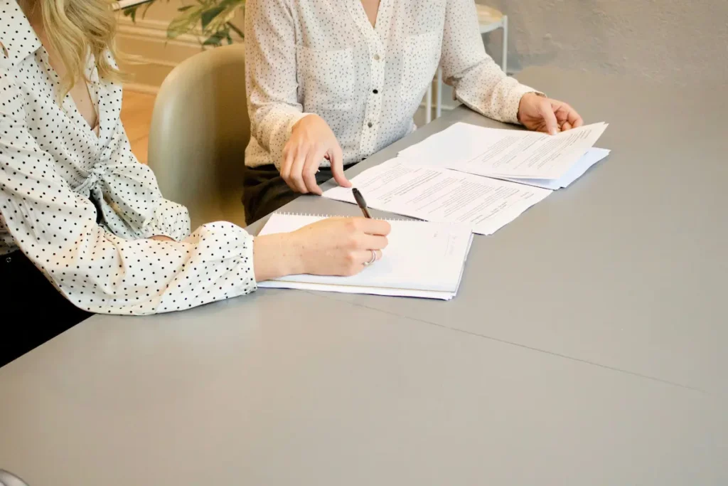 Person signing a legal document at a desk