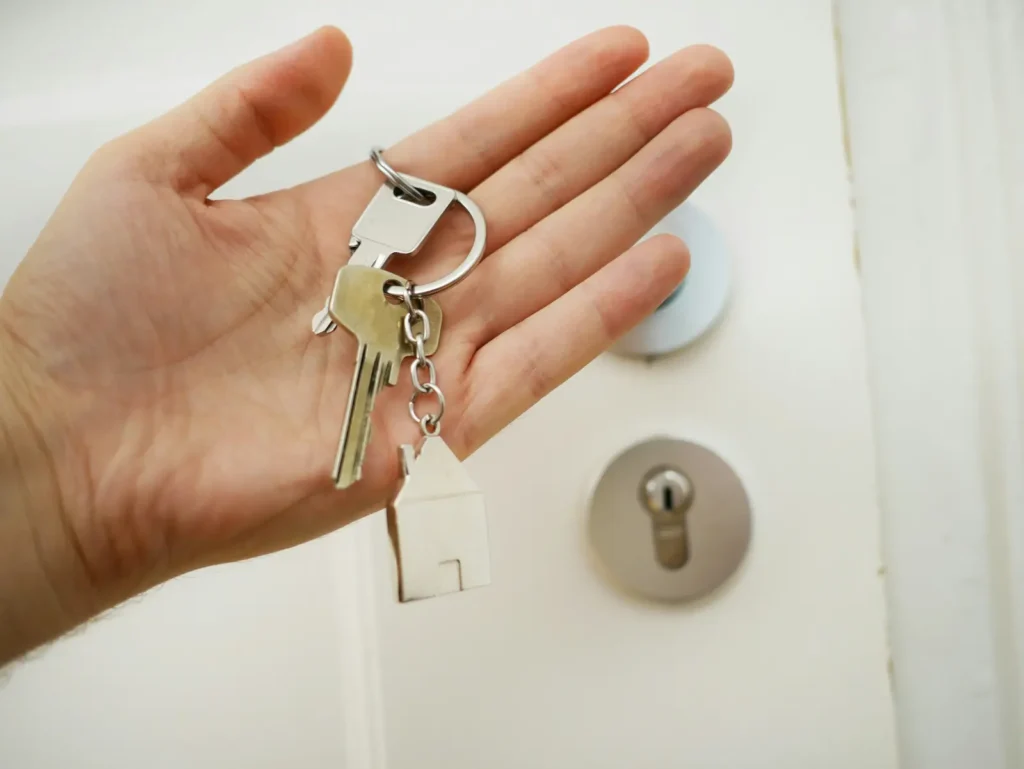 Hand holding keys in front of a door